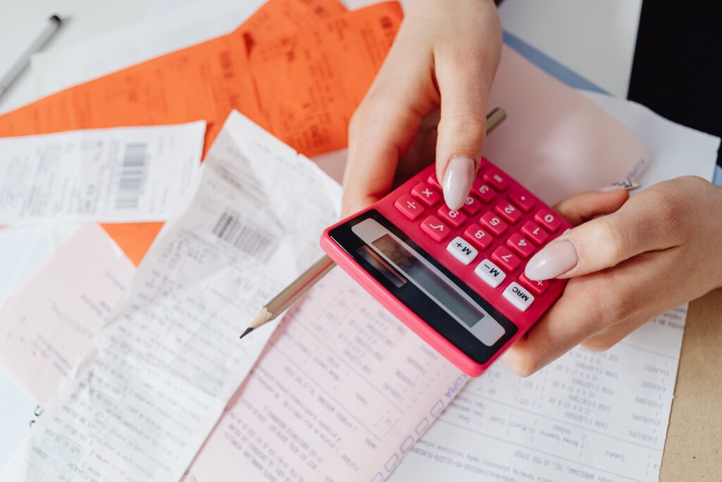 A person holding a calculator trying to do bookkeeping