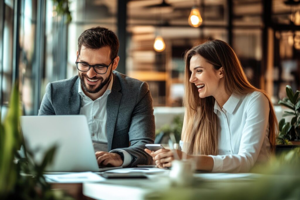 Two business people looking at a laptop and smiling